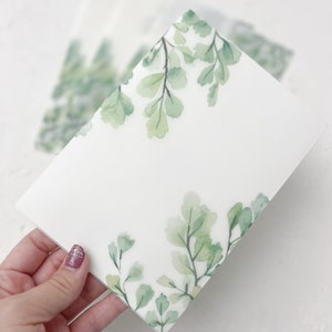 Puede incluir: Una tarjeta blanca con un dise&ntilde;o de helecho acuarela verde en los bordes. La tarjeta est&aacute; en blanco por dentro.