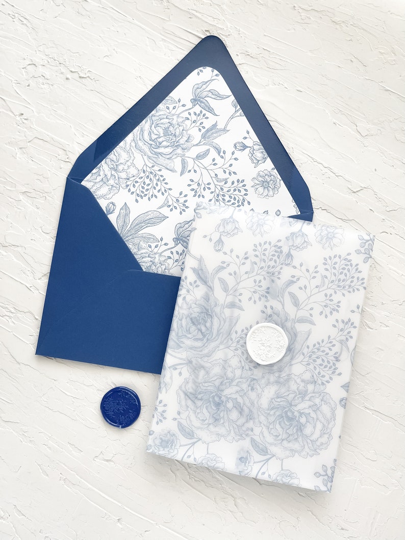Puede incluir: Un sobre azul con un patr&oacute;n floral blanco en el interior. El sobre est&aacute; sellado con un sello de cera azul. Un sobre blanco con un patr&oacute;n floral azul est&aacute; dentro del sobre azul.
