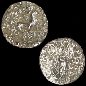 Puede incluir: Dos antiguas monedas de plata con imágenes en relieve detalladas. Una moneda muestra un caballo, la otra una figura. Las monedas tienen un aspecto desgastado y texturizado, lo que sugiere antigüedad e importancia histórica. El fondo es negro.