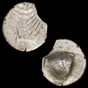 May include: Two ancient silver coins with worn surfaces and partial edges are displayed against a black background. One coin shows a series of lines, while the other has a central design.