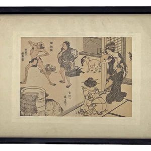 Op de afbeelding: Ingelijste zwart-wit Japanse houtsnede die een huiselijke sc&egrave;ne met figuren en dieren uitbeeldt. Het kunstwerk is geplaatst in een cr&egrave;mekleurige passe-partout en een zwarte houten lijst.