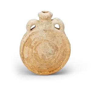 May include: A tan-colored, antique-style ceramic flask with a rounded body and a small, cylindrical neck. It features two loop handles and a circular design on the front. The flask is likely made of earthenware.