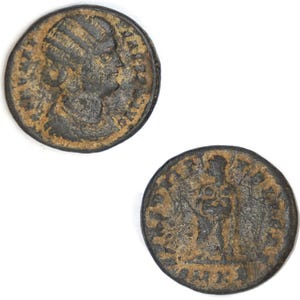 May include: Two antique bronze coins. One coin shows a profile of a person with a detailed headdress. The other coin features a standing figure. Both coins have visible inscriptions and a weathered appearance.