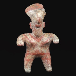 May include: A small, ancient-looking figurine with a stylized human form. The figure is painted in red and white, with a prominent headdress and striped patterns on the torso. The arms are outstretched, and the legs are slightly apart.