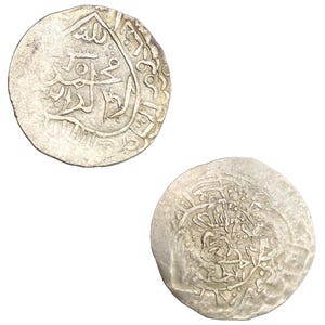Puede incluir: Dos monedas antiguas de plata con intrincadas inscripciones &aacute;rabes. Las monedas circulares, ligeramente desgastadas, se presentan sobre un fondo blanco. Las detalladas inscripciones sugieren una importancia hist&oacute;rica.