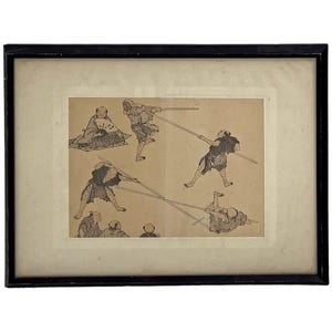 May include: Framed black and white print depicting several figures engaged in a martial arts practice. The artwork features multiple figures in dynamic poses, wielding long weapons. The print is set against a cream-colored background.