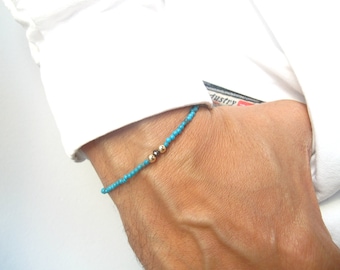 May include: A turquoise beaded bracelet with two gold beads.