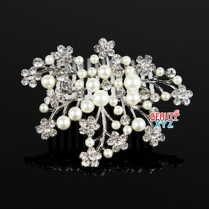 Op de afbeelding: Zilveren haar kam met een bloemmotief met witte parels en heldere strass steentjes.