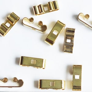 May include: A group of ten gold-colored metal wire connectors. The connectors are designed to connect wires together.