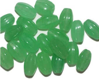 May include: A collection of oval-shaped green jade beads. The beads are smooth and polished, with a translucent appearance.