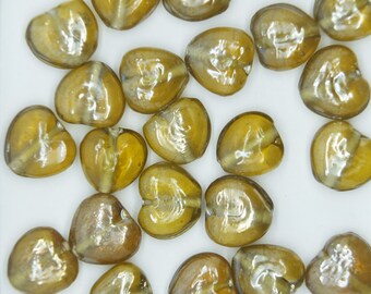 May include: A collection of heart-shaped glass beads in a light brown color with a shimmery finish.