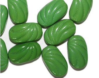 May include: A collection of glossy, oval-shaped green beads. Each bead features a carved, swirling design with a dotted line detail. The beads are scattered against a white background, showcasing their vibrant color and texture.