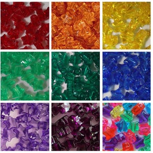 May include: A collection of colorful, translucent star-shaped beads in various colors, including red, orange, yellow, green, blue, purple, and pink. These small, decorative beads are likely used for crafting or jewelry making.