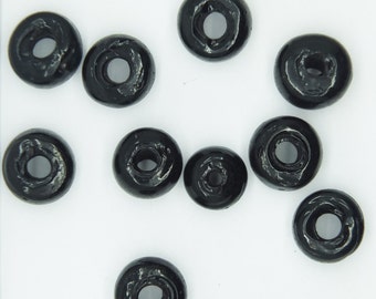May include: Ten black wooden beads with a hole in the center. The beads are round and have a smooth, glossy finish.