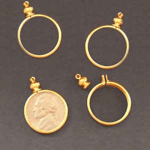May include: Four gold-toned coin bezel pendants, two with a coin inside, and two with a coin-sized opening. The coin inside is a gold-toned US coin with the profile of a man on it.