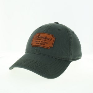 May include: A green baseball cap with a brown leather patch that says "Blanton's Single Barrel Bourbon".