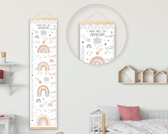 May include: A white growth chart with a rainbow, stars, and clouds design. The chart is labeled "How Tall Is Jessica?" and has measurements in inches and centimeters. The chart is hanging on a white wall in a child's room.