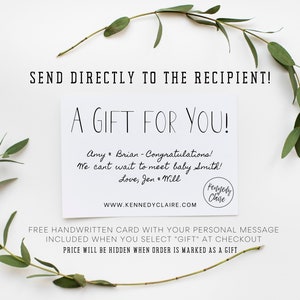May include: A white gift card with the text "A GIFT FOR YOU!" and handwritten message. The card is surrounded by greenery and the text "SEND DIRECTLY TO THE RECIPIENT!" is at the top. The website address is www.kennedyclaire.com.