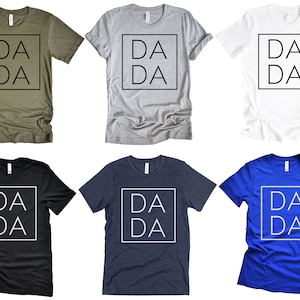 Puede incluir: Seis camisetas de diferentes colores con el texto "DA DA" dentro de un cuadrado en la parte delantera.