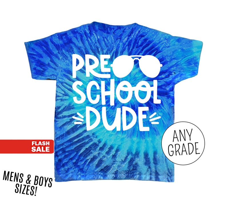 Op de afbeelding: Een blauw tie-dye t-shirt met de witte woorden "PRE SCHOOL DUDE" en een witte zonnebril. Het shirt heeft ook de woorden "ANY GRADE" in een cirkel. Het shirt is voor "MENS & BOYS SIZES!"