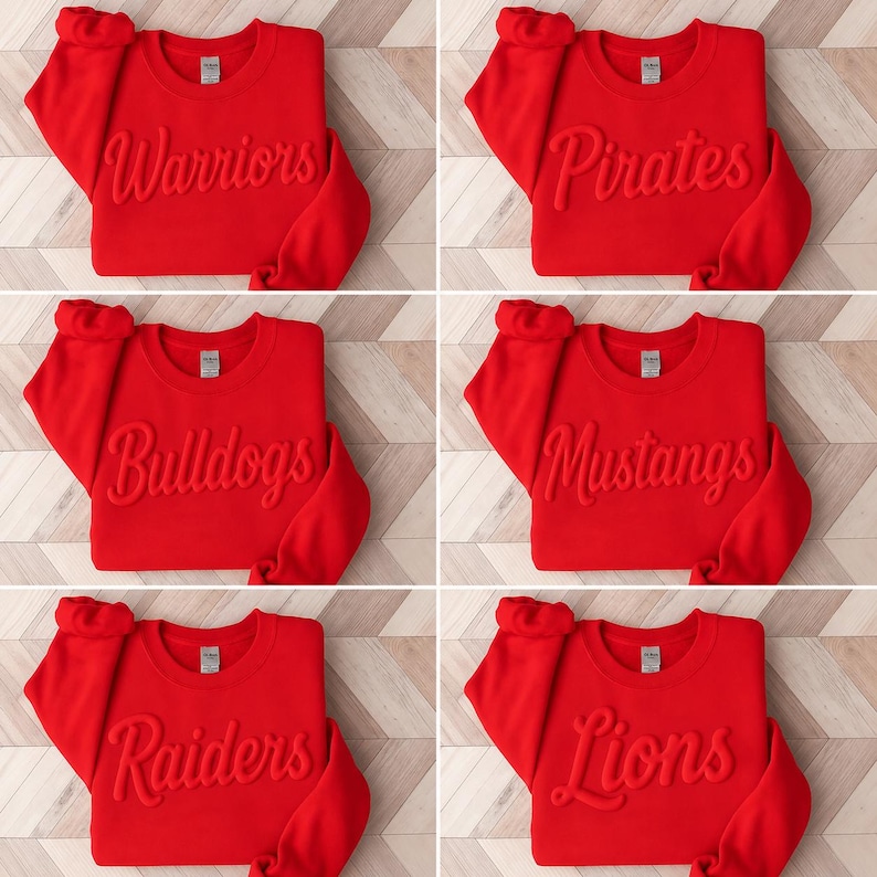 Puede incluir: Una colecci&oacute;n de seis sudaderas de cuello redondo en color rojo brillante, cada una con un nombre de equipo diferente grabado en relieve con letra cursiva en el pecho. Los nombres son Warriors, Pirates, Bulldogs, Mustangs, Raiders y Lions. Cada prenda tiene mangas largas y cuello acanalado.