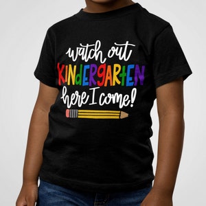 May include: A black t-shirt with the text "Watch out Kindergarten here I come!" in rainbow colours and a yellow pencil with a red eraser.