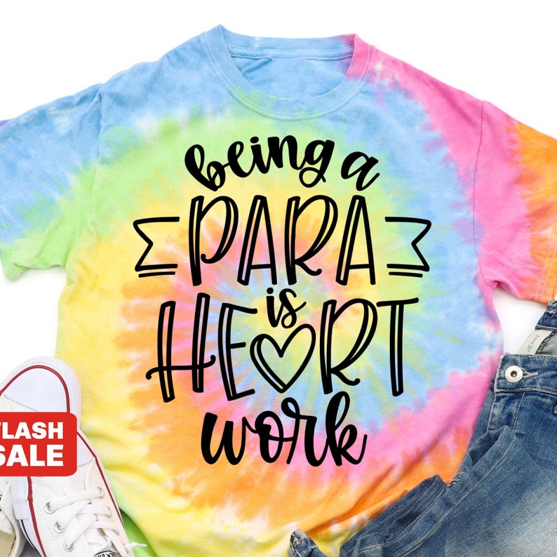 Puede incluir: Una camiseta tie-dye con el texto "being a para is heart work" en letras negras.