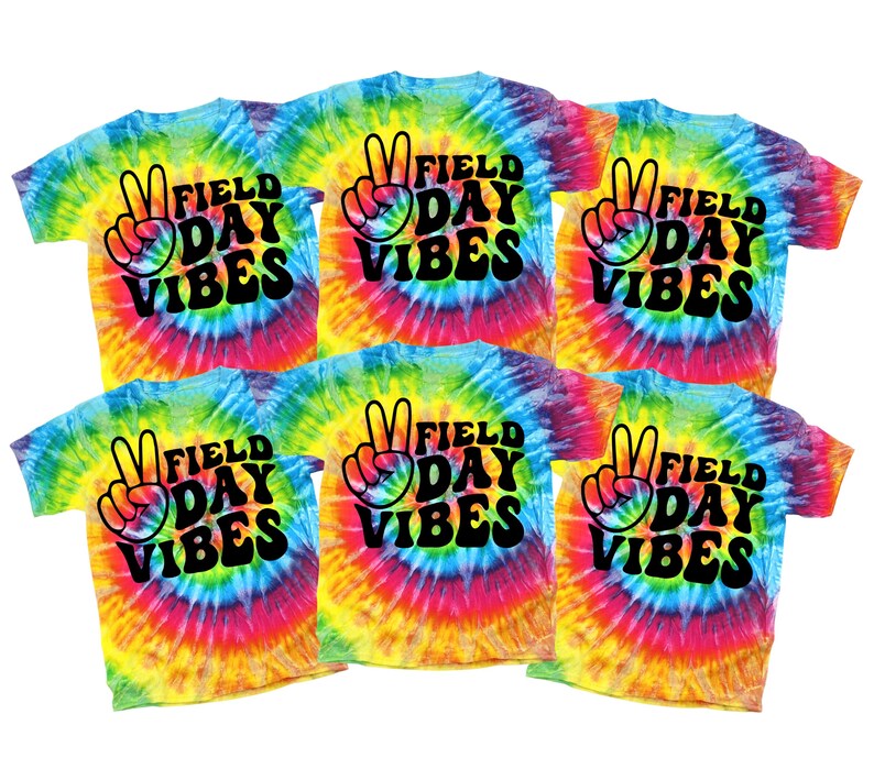 Puede incluir: Seis camisetas te&ntilde;idas con la inscripci&oacute;n "Field Day Vibes" en escritura negra y un gr&aacute;fico de signo de la paz. Las camisetas tienen un patr&oacute;n de remolino arco&iacute;ris de azul, amarillo, rosa y naranja.