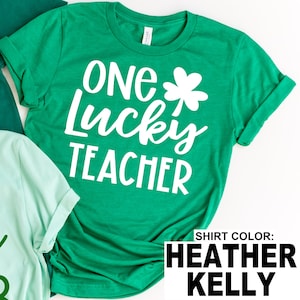 May include: A green t-shirt with the text "ONE Lucky TEACHER" in white, along with a white shamrock. The shirt is a Heather Kelly color.