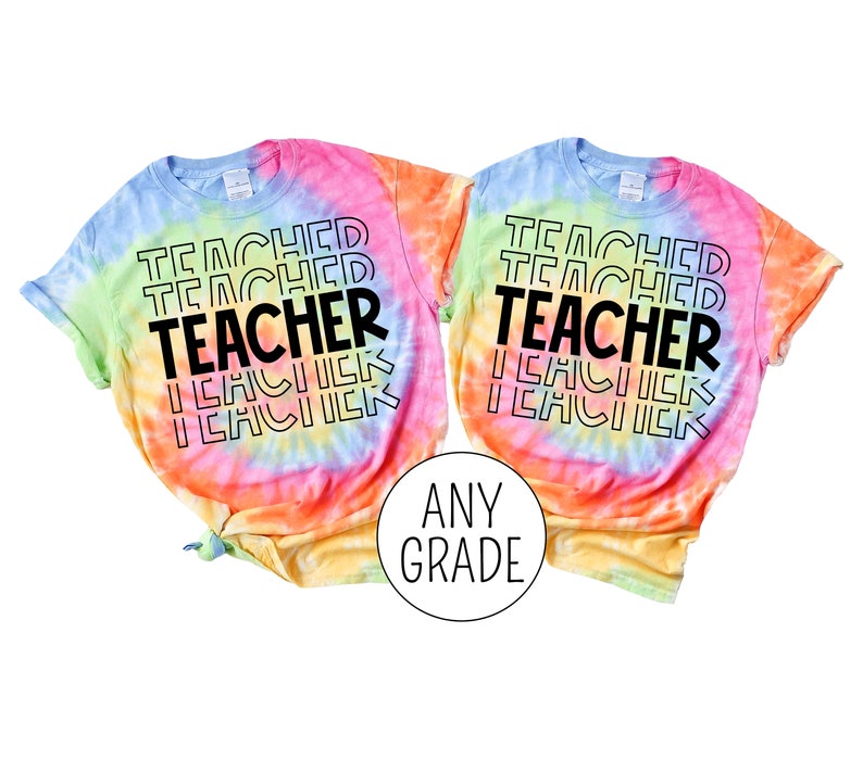 Pu&ograve; includere: Due magliette tie-dye con il testo "Teacher" ripetuto in uno schema impilato. Le magliette sono in tonalit&agrave; di rosa, arancio, giallo e blu. Il testo &egrave; nero. Le magliette sono etichettate "Any Grade".