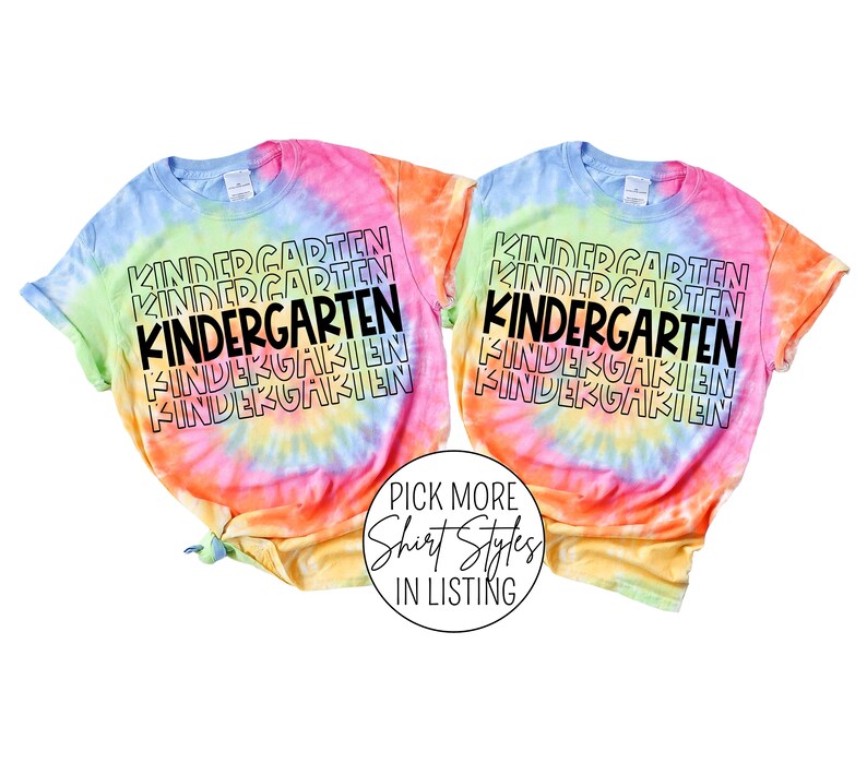 May include: Two tie-dye t-shirts with the word "KINDERGARTEN" repeated in a stacked pattern. The shirts are a rainbow of colors, including pink, orange, yellow, green, and blue.