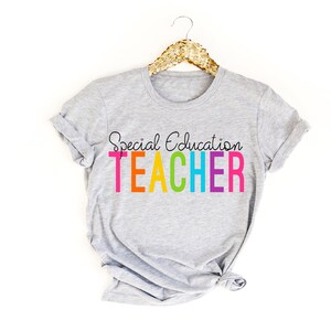 May include: Gray t-shirt with the text "Special Education Teacher" in rainbow colors.