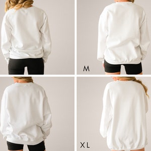 May include: Four images showing a white sweatshirt in different sizes: S, M, L, and XL. The model is wearing black shorts and the sweatshirt is shown from the back.