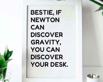 May include: White framed print with black text that reads "Bestie, if Newton can discover gravity, you can discover your desk."