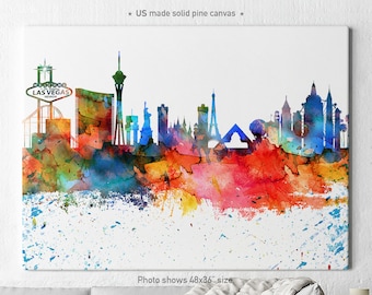 May include: A watercolor painting of the Las Vegas skyline with a colorful splatter effect. The painting features iconic landmarks like the Welcome to Fabulous Las Vegas sign, the Stratosphere Tower, and the Bellagio Fountains. The painting is on a white canvas with a white background.