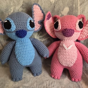 May include: Two crocheted plush toys, one blue and one pink, resembling the characters Stitch and Angel from the Disney movie Lilo & Stitch.
