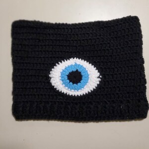 May include: Black crocheted headband with a white and blue evil eye design.