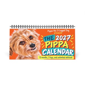 May include: A spiral-bound 2027 wall calendar with an orange background featuring a portrait of a light brown dog. The text reads: Pippa the 3-Legged Dog presents THE 2027 PIPPA CALENDAR 12 months, 3 legs, and unlimited attitude.