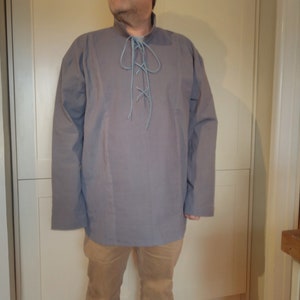 May include: A gray long-sleeved shirt with a lace-up neckline. The laces are light blue.