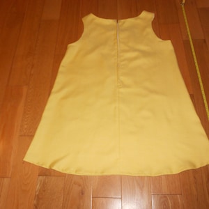 May include: A sleeveless yellow dress with a zipper down the back.