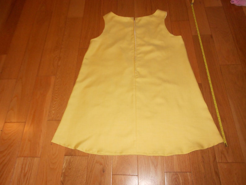 May include: A sleeveless yellow dress with a zipper down the back.