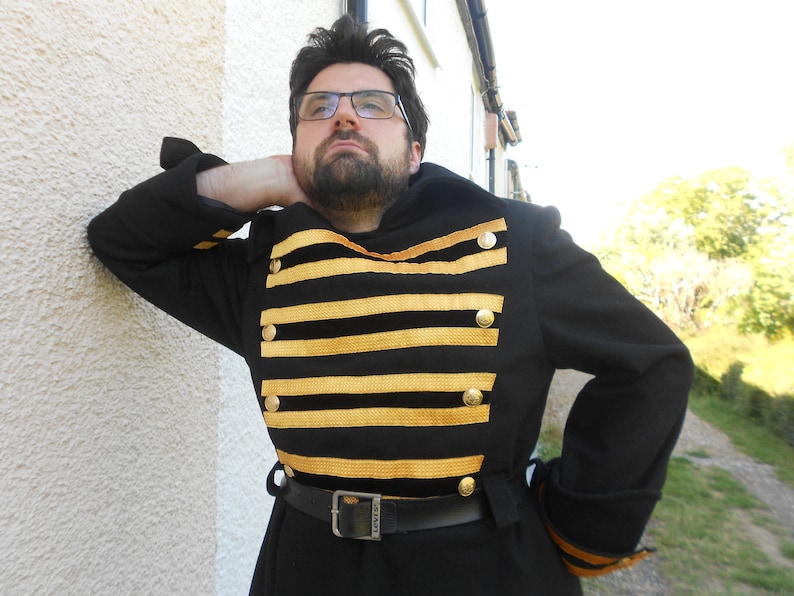 May include: A black coat with gold trim and buttons. The coat has a striped pattern on the front and a belt around the waist.