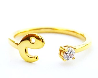 Könnte beinhalten: Ein goldener Ring mit einem einzigen klaren Stein und einem einzigartigen offenen Design in Form des Buchstabens 'e'.