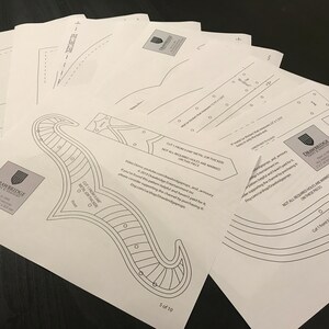 Op de afbeelding: Een set van tien afdrukbare papieren patronen voor het maken van een metalen helm. De patronen zijn zwart-wit lijntekeningen met instructies voor het snijden en monteren. De patronen zijn gelabeld met de tekst "Drawbridge Metal of the Realm" en "Niet alle benodigde gaten zijn gemarkeerd op dit onderdeel".