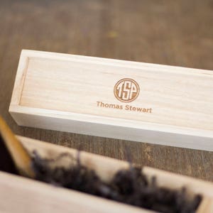 May include: A wooden box with a personalized engraved monogram "TSP" and the name "Thomas Stewart".
