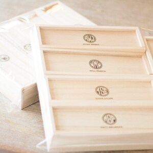 May include: A wooden box with five drawers, each with a different monogram and name. The names are Ryan Weeks, Will Munch, Eddie Salem, Matt Monroe, and John Harrelson.