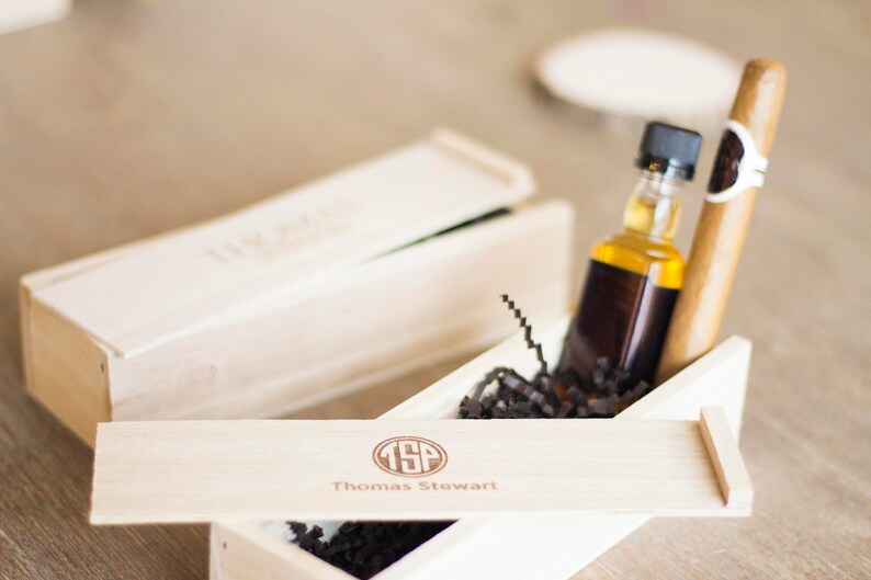 May include: A wooden box with a lid, containing a small bottle of liquor and a cigar. The box is engraved with the initials "TSP" and the name "Thomas Stewart".