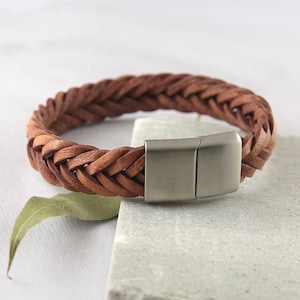 May include: A brown leather braided bracelet with a silver magnetic clasp.