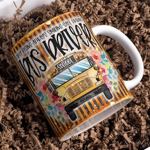 May include: White ceramic mug with a yellow school bus graphic, black and yellow stripes, and the text "Early rising - always smiling - safe driving Bus Driver".