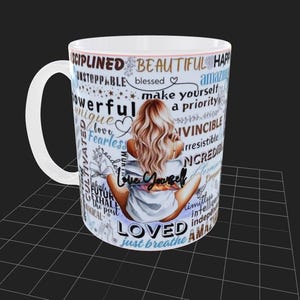 Puede incluir: Taza de cer&aacute;mica blanca con una mujer de pelo rubio, sentada de espaldas al espectador. La taza est&aacute; adornada con palabras inspiradoras como "Love Yourself", "Beautiful" y "Loved".